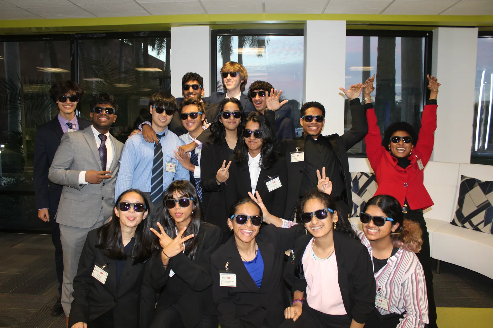 The 2023-24 finalist cohort in business dress and sunglasses, posing
                    together after the awards ceremony.