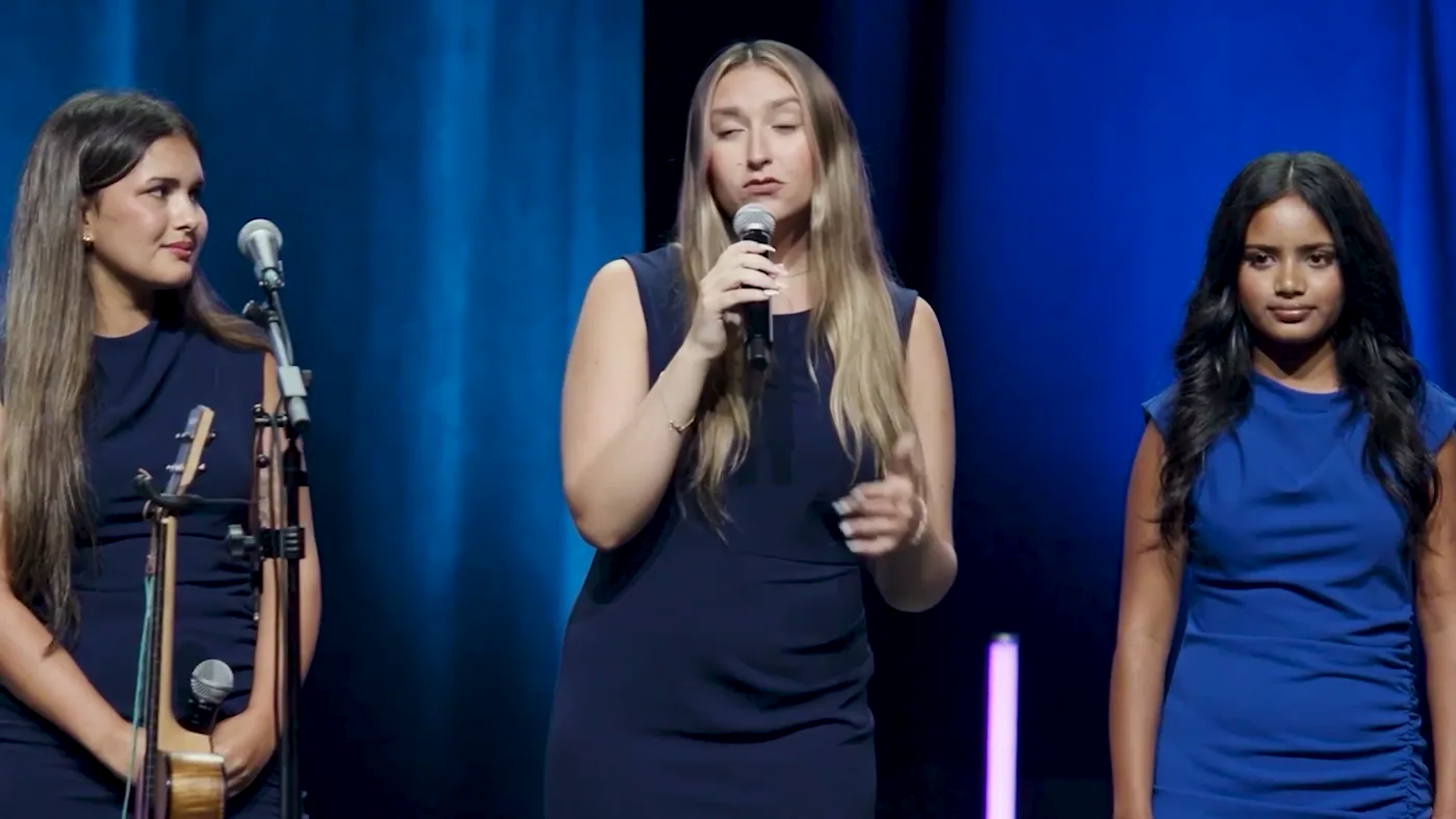 Three SharkMakers students presenting their product on stage at the season pitch event.